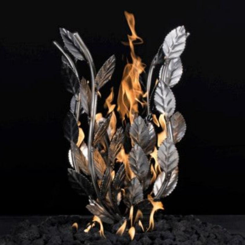 Decorative metal fire bowl with leaf design and flames on a black background