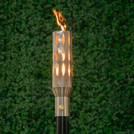Sleek Ellipse 304 Stainless Steel Torch head and 68-inch mounting post by The Outdoor Plus in garden setting.