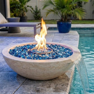 Fire pit with blue glass stones by a poolside