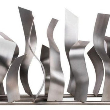 Metallic abstract sculpture with wavy patterns on a white background